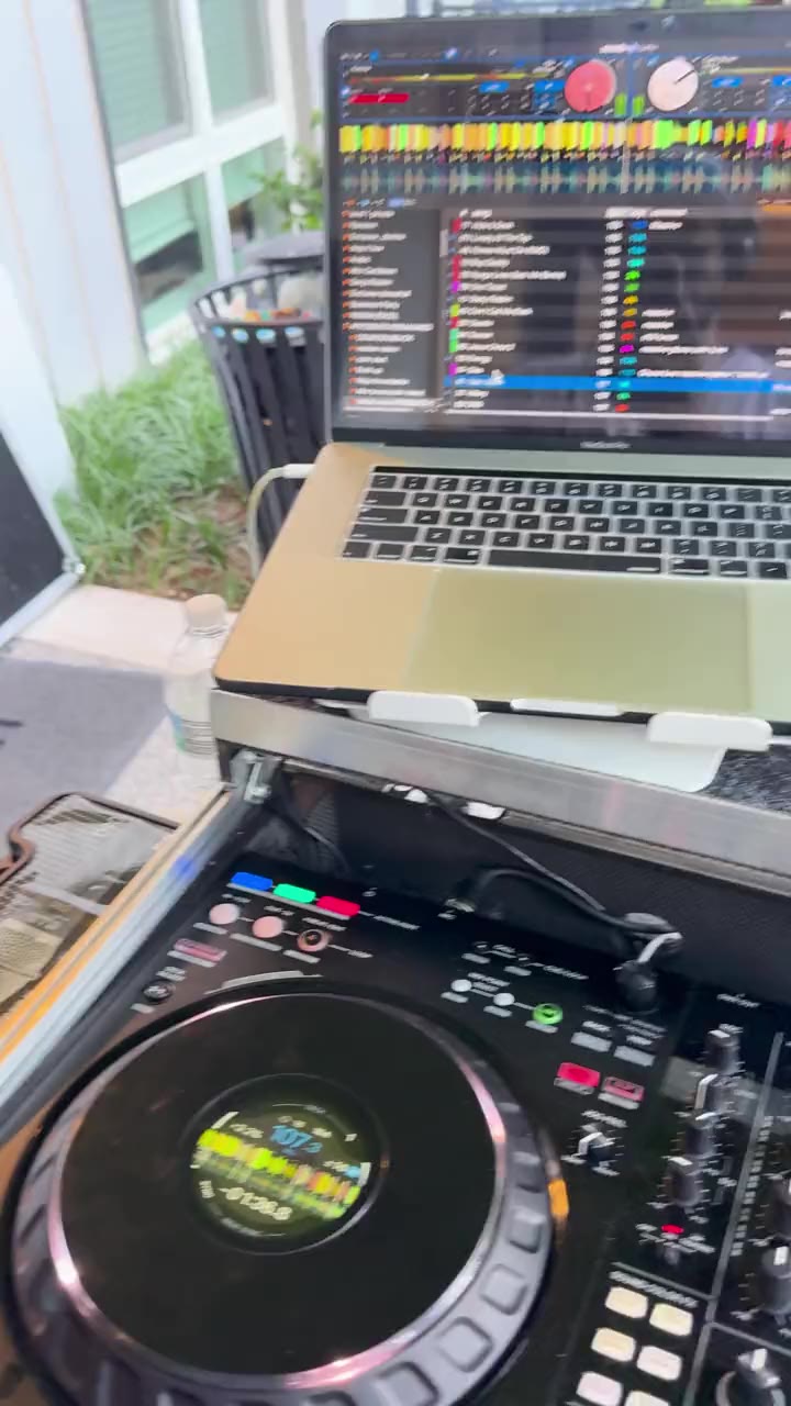 Video from behind DJ Pharoh's decks at an outdoor day party in Richmond, Virginia: his laptop and controller, then the crowd dancing under green umbrellas.